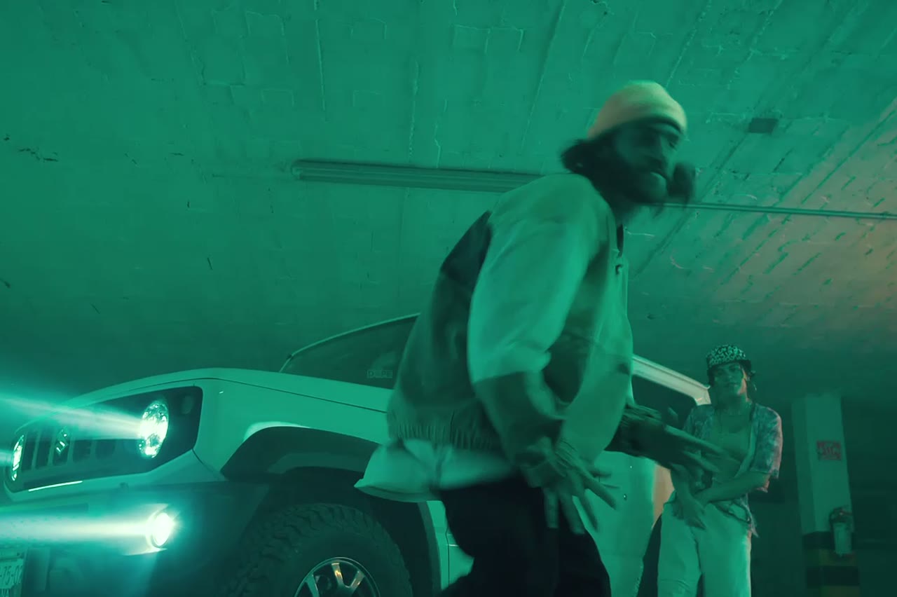A cold blue rooftop scene with a performer in a hoodie, AI hip hop video frame